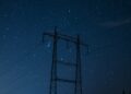 black electric post under blue sky during night time