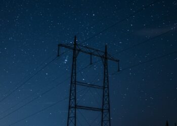 black electric post under blue sky during night time