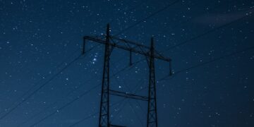 black electric post under blue sky during night time